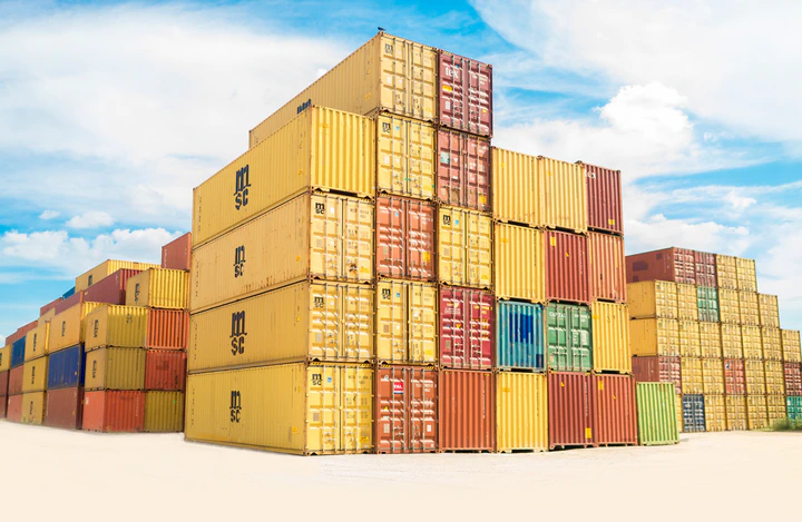 Shipping containers stacked on top of each other with a blue sky background